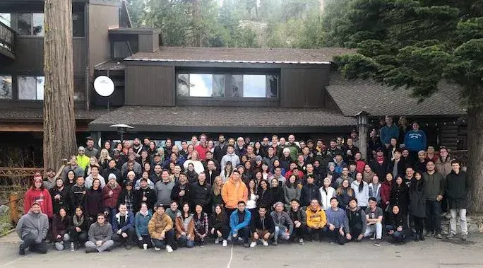 Quora team group photo outside a wooden lodge